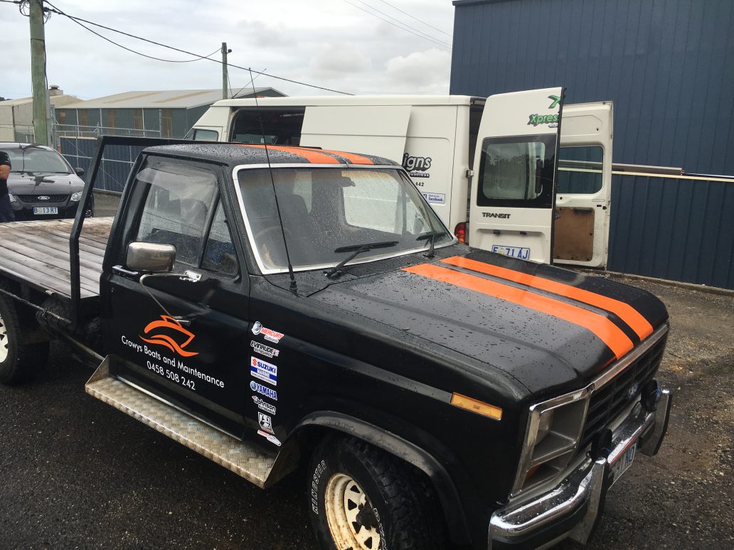 Vehicle door decals on a black flatbed ute for Crows Boats and Maintenance